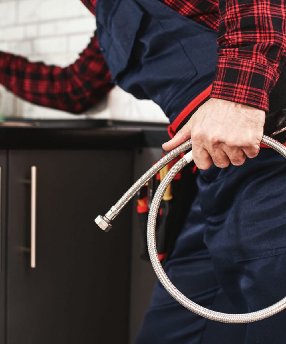 New plumbing. Close-up of foreman checking all things in kitchen sink before push faucet. Cropped photo